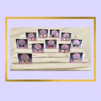 a group of pink and purple stud earrings on a wooden stand