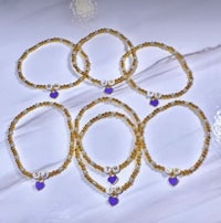 a set of bracelets with gold and purple beads